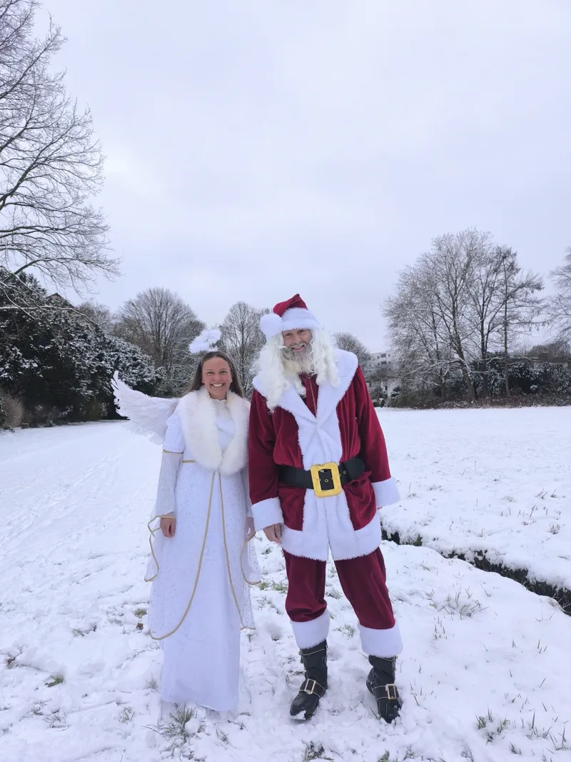 Weihnachtsmann und Engel gemeinsam im Schnee